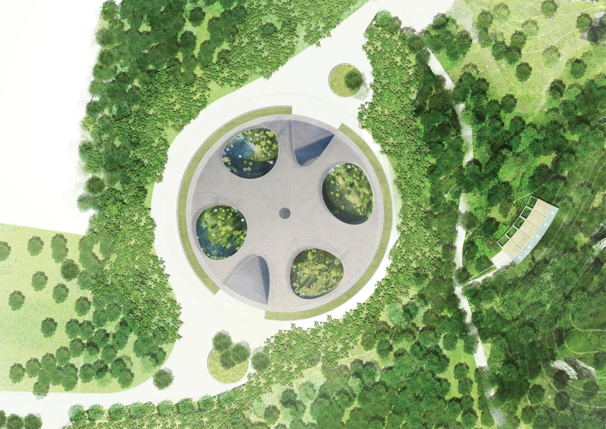 Aerial view of circular concrete pavilion with four circular openings in a green park with winding paths.