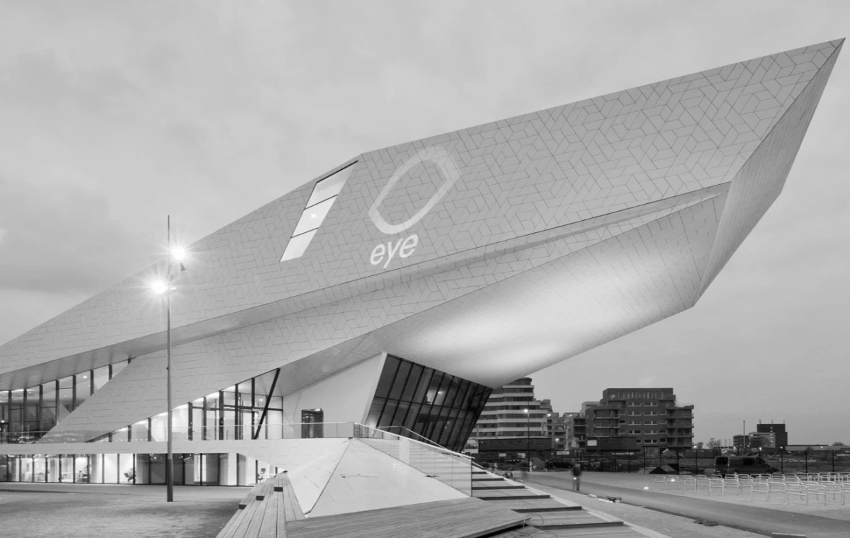 Exterior of the Eye Film Institute, a futuristic angular building with a slanted roof and the eye logo, in a city plaza.