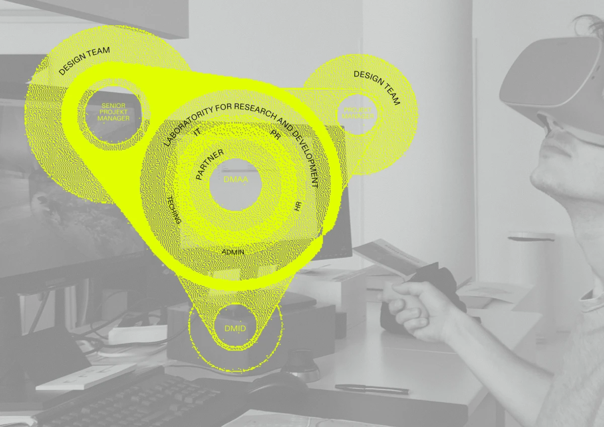 Person wearing a virtual reality headset at a desk in an office.
