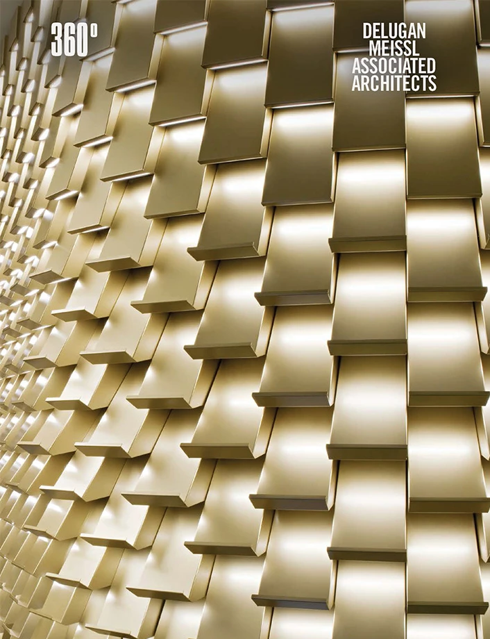 Gold-toned architectural facade with a tessellated, protruding grid of angled rectangular panels.