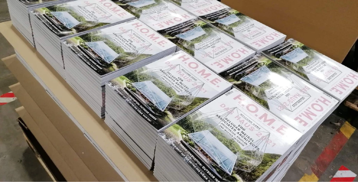 Stacks of HOME magazine issues on a pallet in a warehouse.