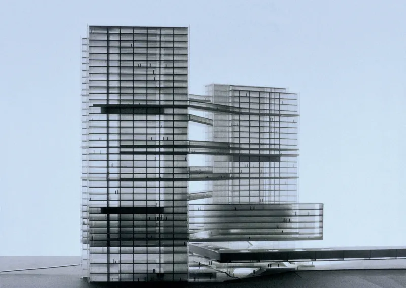 Architectural model of a glass-and-steel tower complex connected by elevated skybridges on a flat surface