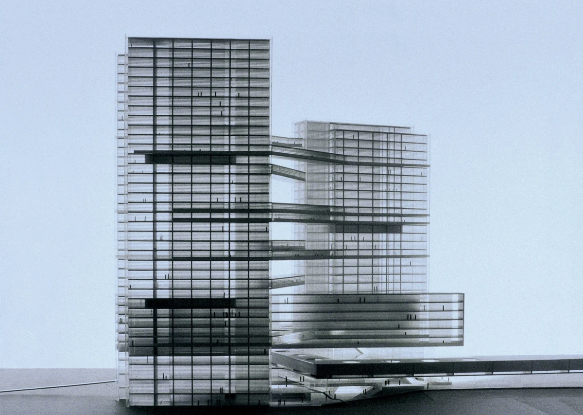 Architectural model of a glass-and-steel tower complex connected by elevated skybridges on a flat surface