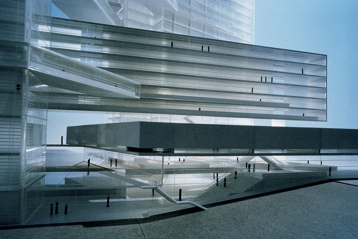 Interior of a modern glass-and-steel atrium with overlapping transparent walkways and suspended platforms.