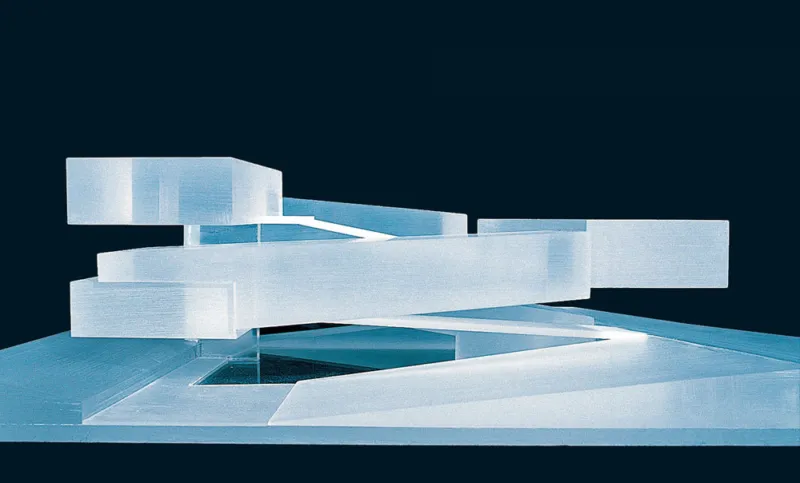 Abstract sculpture of interlocking white rectangular prisms arranged in a spiral over a pale blue platform against a dark blue background.
