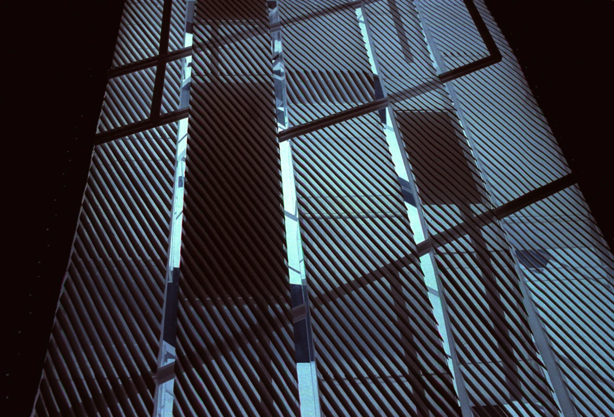 Close-up of blue metal louvers on a modern building facade, viewed at an angle.
