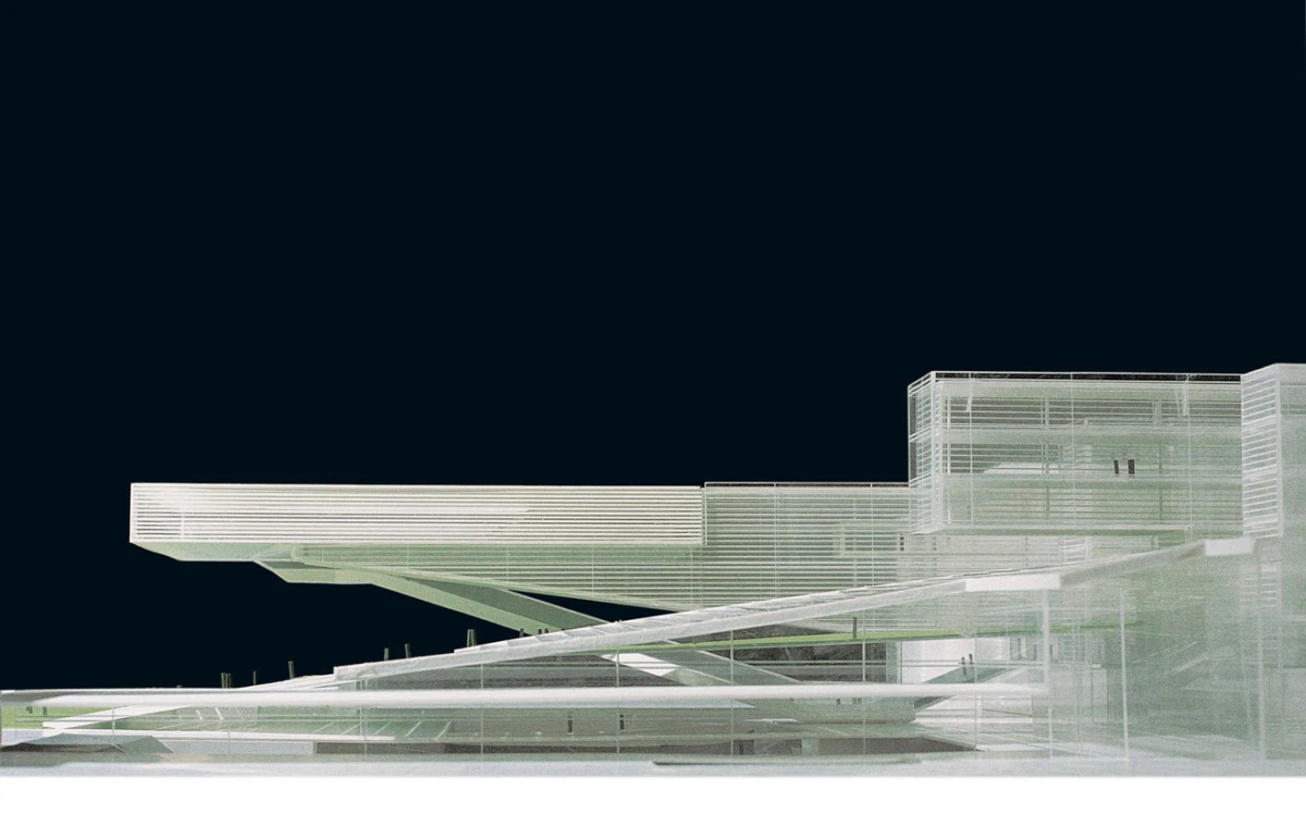 Futuristic glass-and-steel building with elevated walkways and diagonal supports against a dark night sky