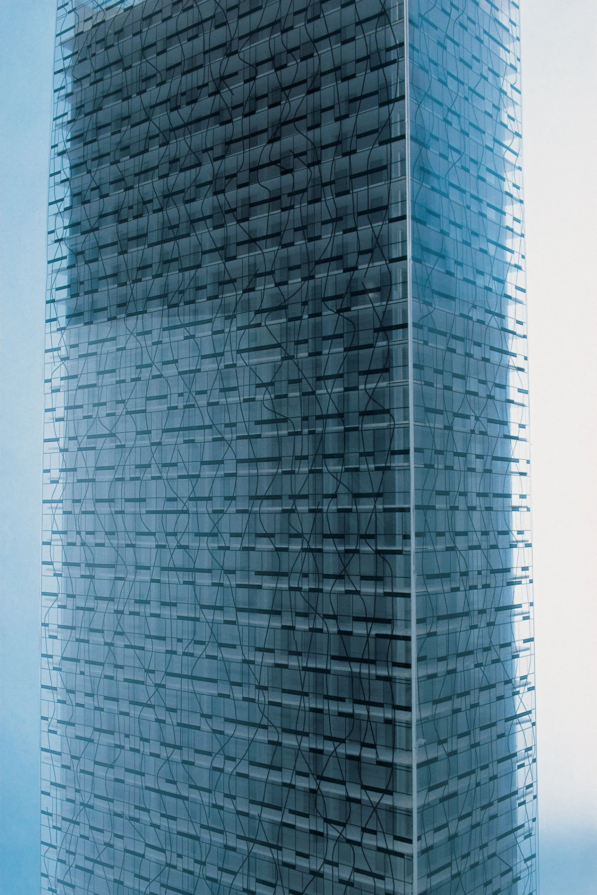Glass-clad skyscraper featuring a geometric lattice pattern on its facade in an urban skyline.