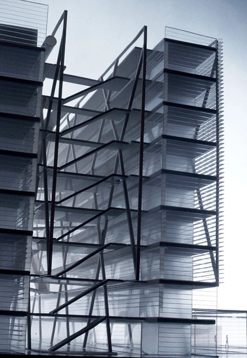Two glass-clad office towers connected by a crisscross steel framework in daylight.