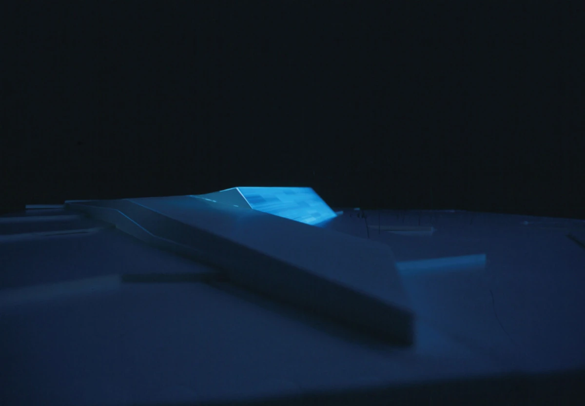 Blue-tinted close-up of white plastic clothespins resting on a smooth surface in low light.