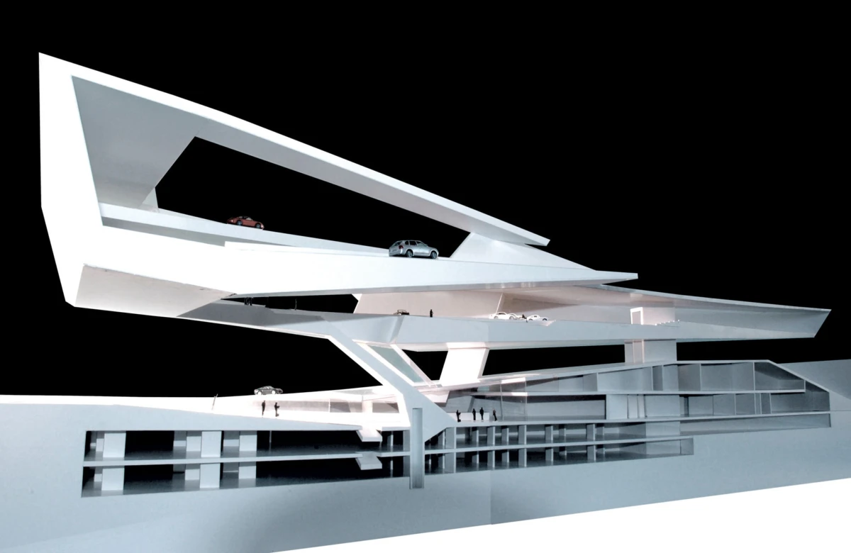 Futuristic white multi-level parking structure with cantilevered ramps; cars parked on upper levels against a black sky.