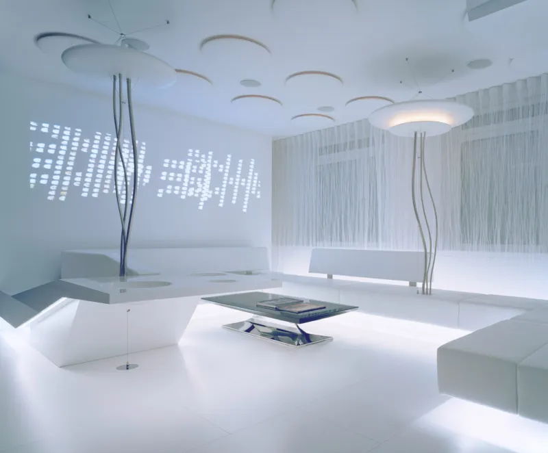Futuristic white lounge with angular sofas, sculptural floor lamps, and a glass coffee table in a bright minimalist room.