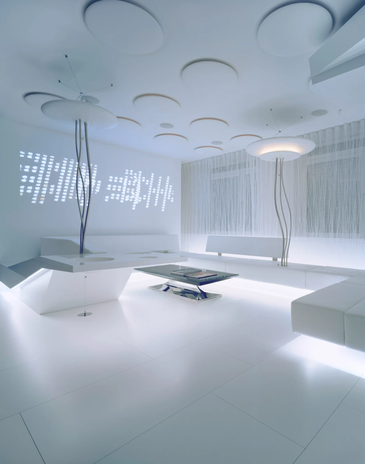 Futuristic white lounge interior with circular ceiling panels, slender curved supports, white sofas, and a glass coffee table.