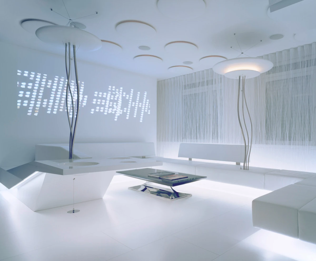 Futuristic white lounge with angular sofas, sculptural floor lamps, and a glass coffee table in a bright minimalist room.