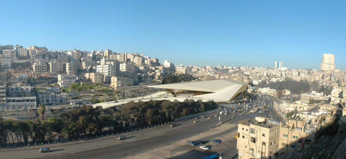 Panoramic view of a futuristic angular building dominating a dense hillside city, with a busy multi-lane road in the foreground.