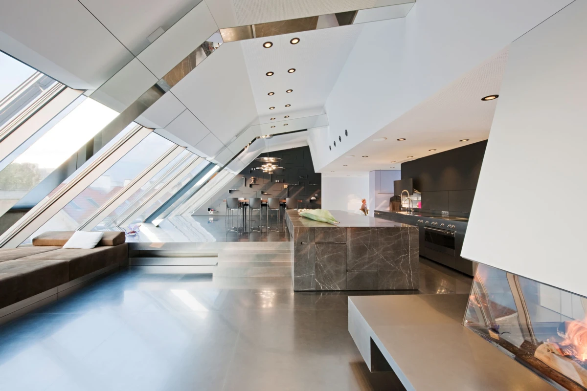 Empty futuristic open-plan living space with angular white walls, slanted glass windows, marble kitchen island, and fireplace.