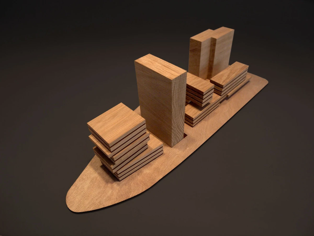 Wooden architectural model of a city with stacked rectangular blocks of varying heights on a curved base.