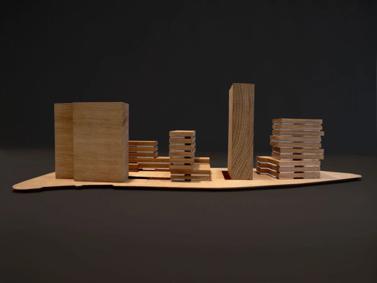 Wooden block city model on a curved wooden base, with varying tower heights against a dark background.