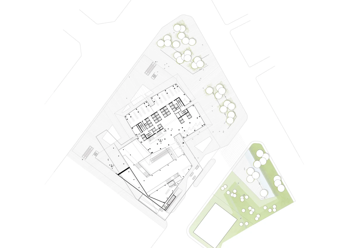 Aerial site plan of a building complex with central footprint and surrounding landscaped areas with trees.