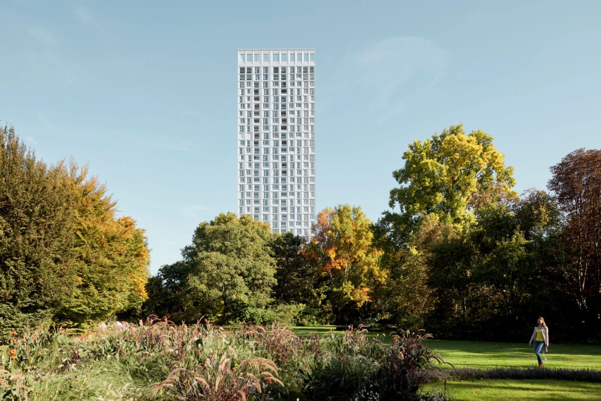 Tall white high-rise tower rises over a leafy autumn park; a person walks along a path on the right.