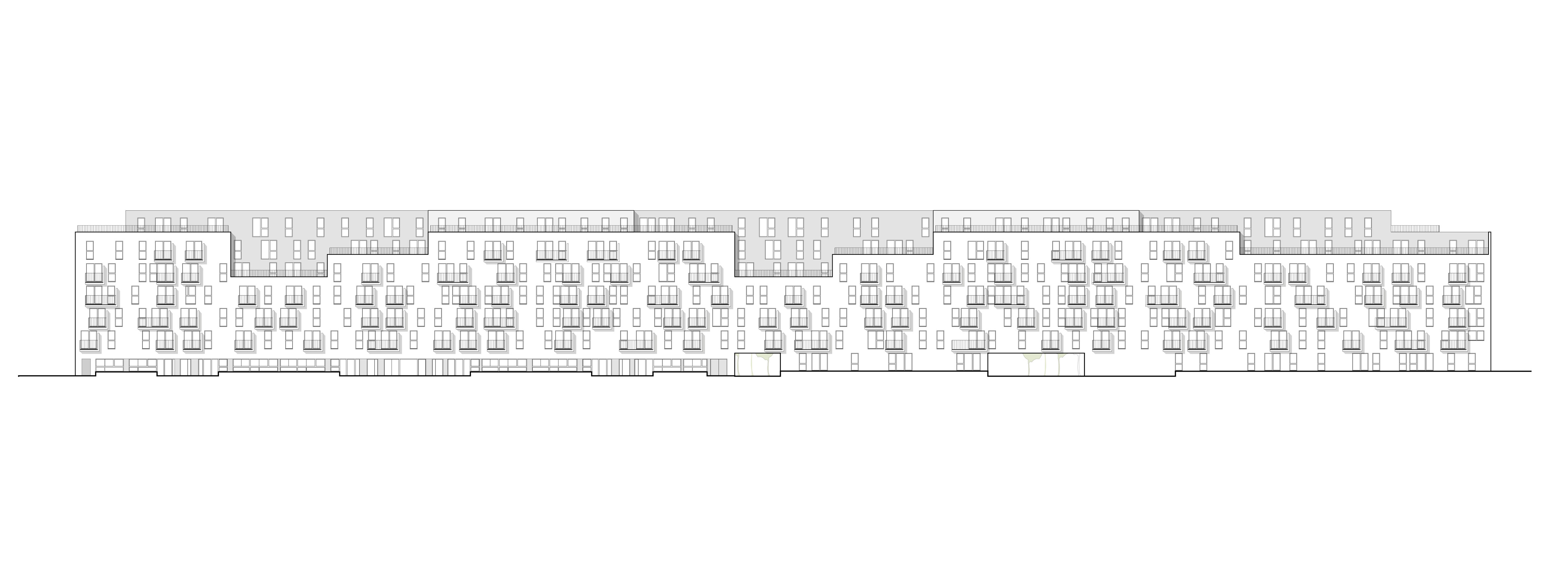 Long multi-story apartment building with numerous balconies and windows along a street.