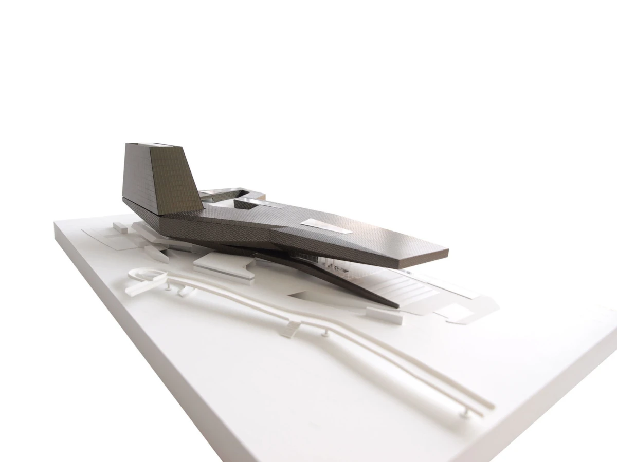Black angular concept aircraft model on a white display base.