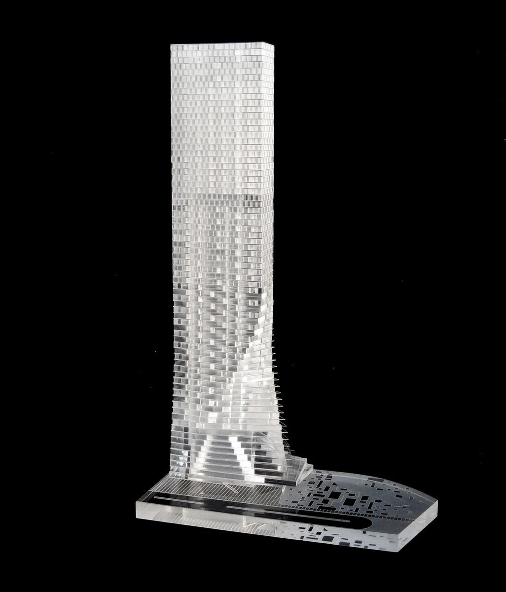 Clear acrylic architectural model of a tall skyscraper on a display base against a black background.