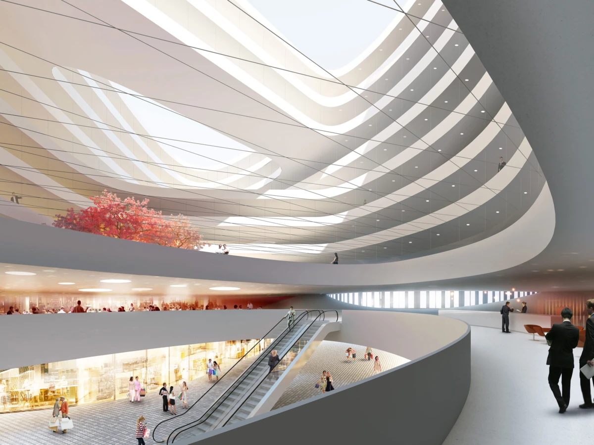 Spiral, multi-level white atrium with curved balconies, escalators, and people walking; red-leaf tree centerpiece under a large skylight.