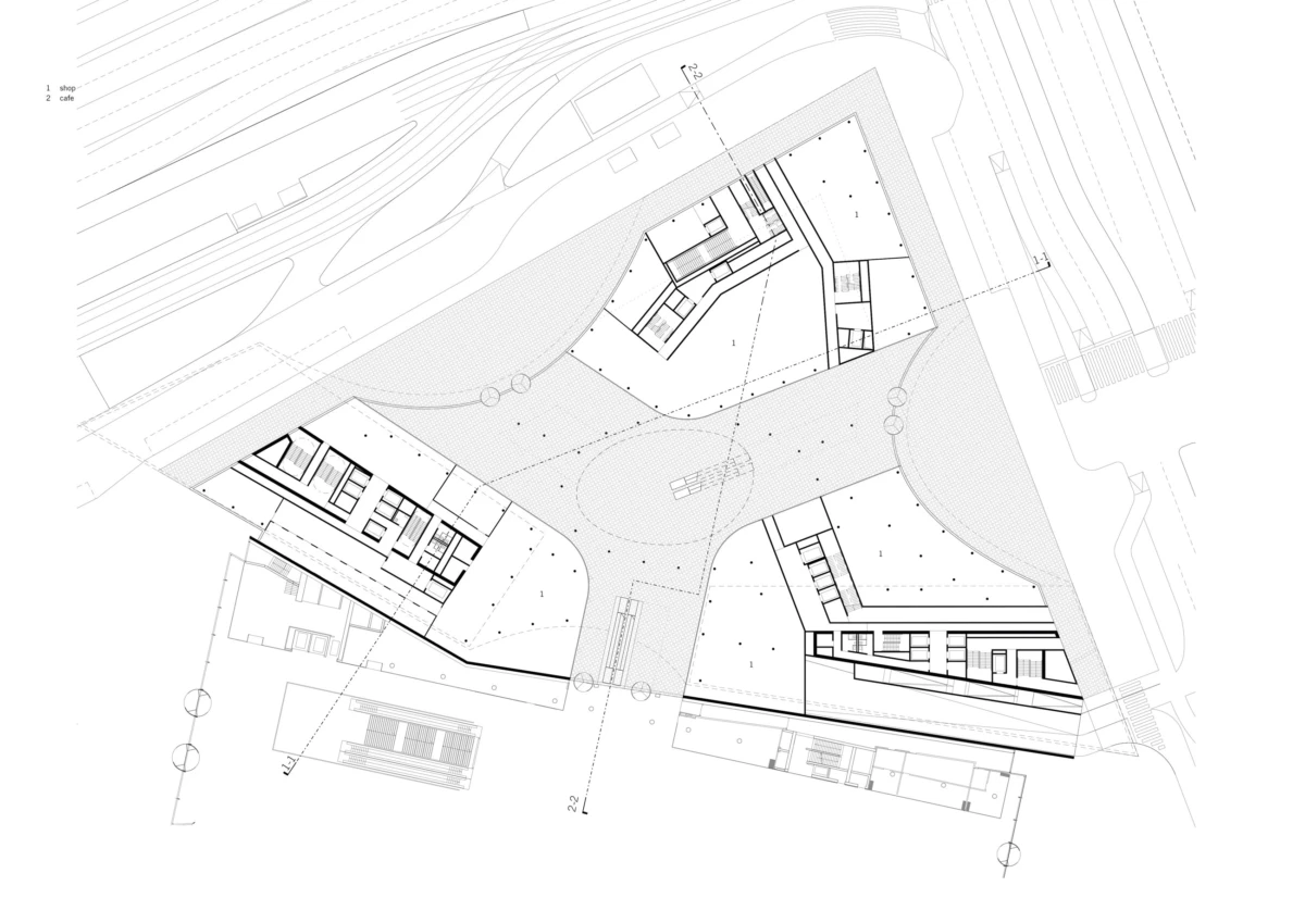 Architectural site plan of a triangular building complex around a central plaza, with connecting walkways and surrounding roads.