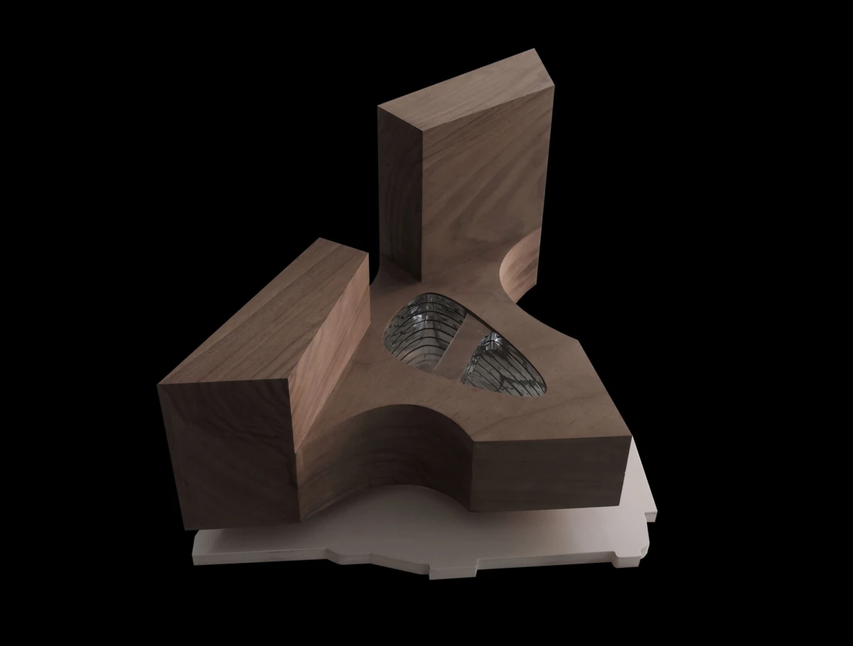 Wooden abstract sculpture with a curved notch and circular opening housing metal springs, on a white base against a black background.