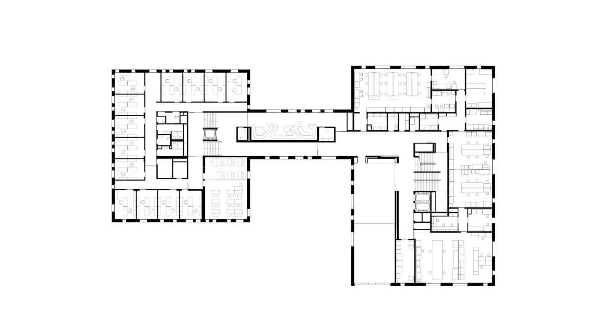 Architectural floor plan of a two-wing office building connected by a central corridor; numerous offices, meeting rooms, and workstations.