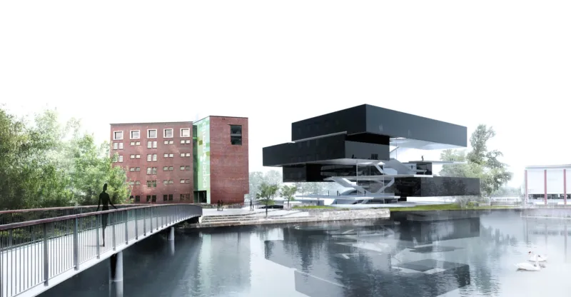 Pedestrian on a bridge over a calm river toward a futuristic black, stacked building beside a brick multi-story structure.