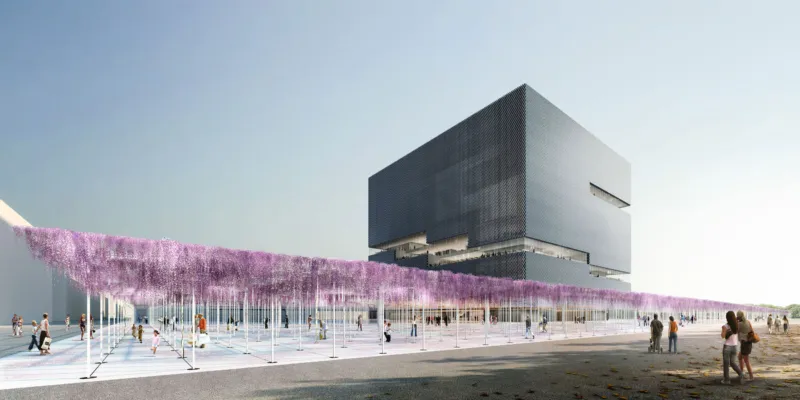 Modern stacked black cubic building behind a plaza with purple wisteria and pedestrians strolling.