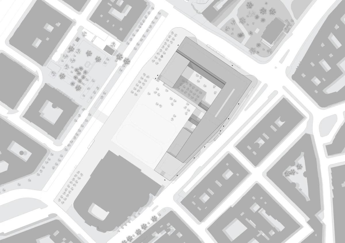 Aerial grayscale site plan of a large L-shaped building complex with central courtyard, surrounded by streets and blocks.