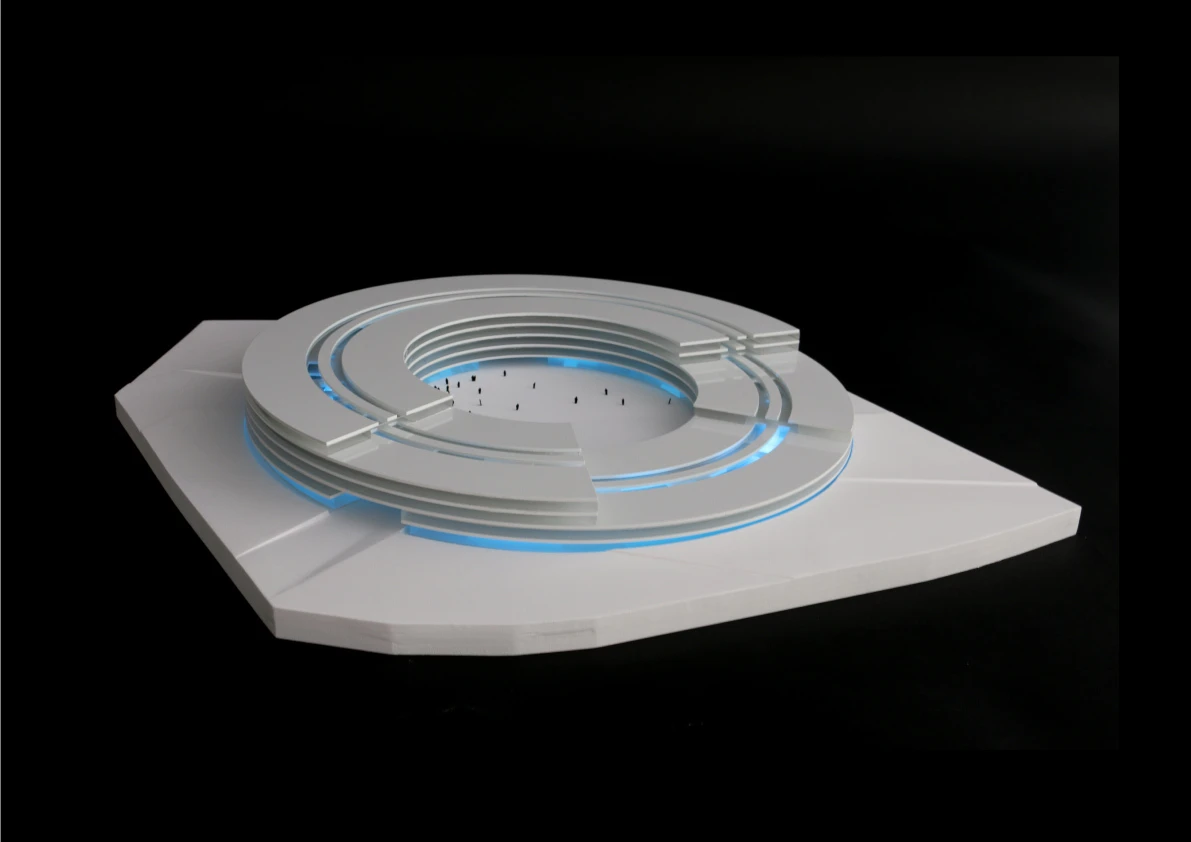 White circular, multi-tier arena model with blue accent lighting on a square base against a black background.