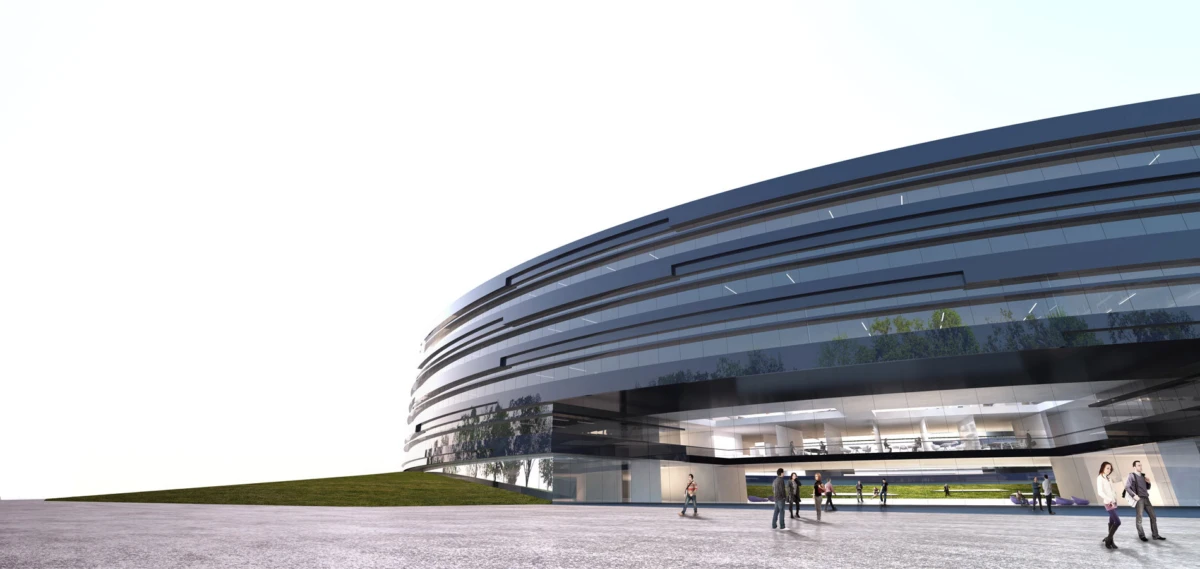 Modern circular glass-clad building with people walking near the entrance; outdoor plaza and grassy slope in daylight.