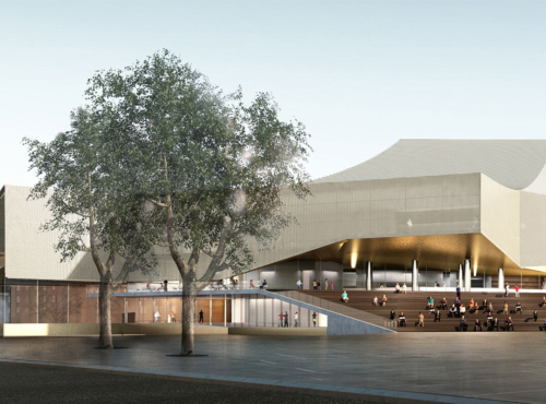 Modern cultural center with a broad stairway; people sit and walk on the open plaza under trees in front of the building.