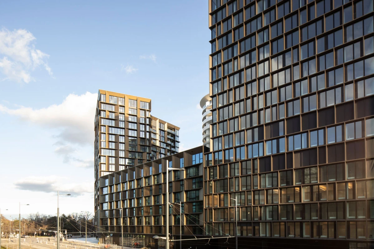 High-rise glass-clad apartment buildings in an urban setting.
