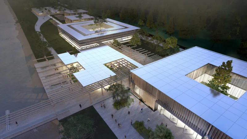 Aerial view of a modern architectural campus with white flat-roofed pavilions, timber screens, and central courtyards along a riverside.