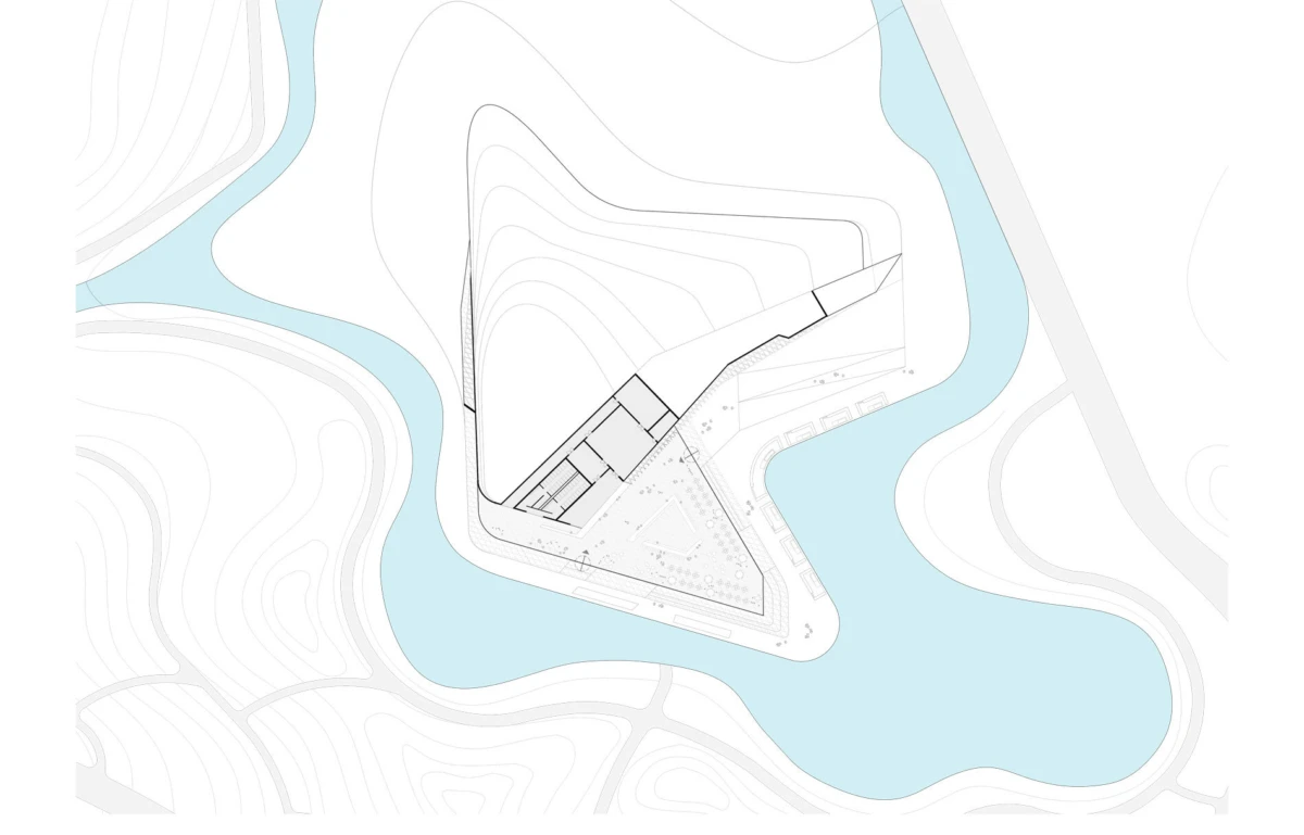 Site plan of a triangular building on a peninsula surrounded by water, with topographic contours.