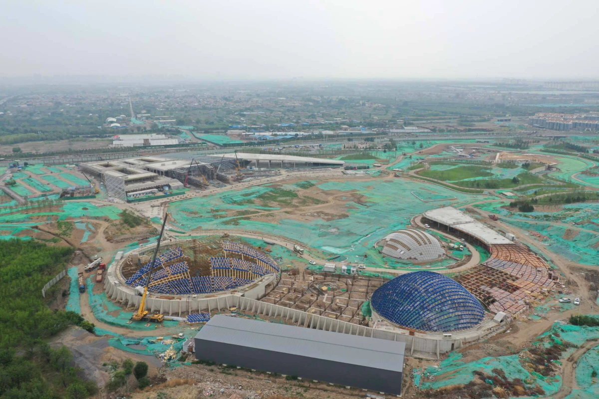 Aerial view of a large construction site with circular and glass-domed structures.