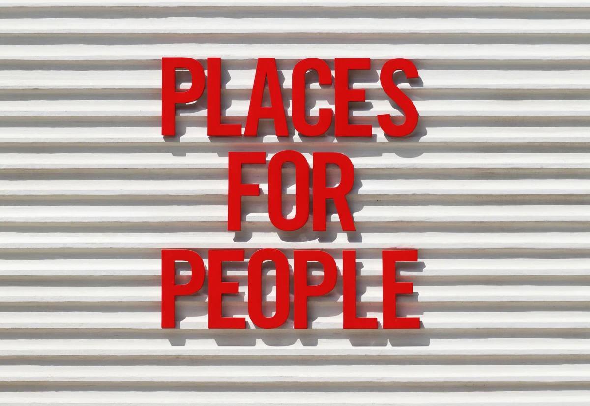 Red letters spell 'PLACES FOR PEOPLE' on a white corrugated wall.