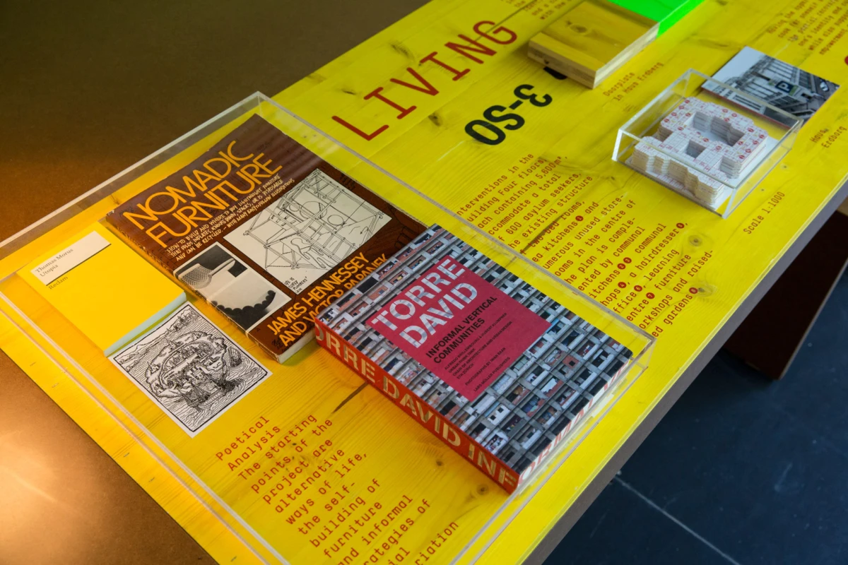 Two hardcover books on a bright yellow display table in an exhibit; an orange-covered book titled Modern Furniture.