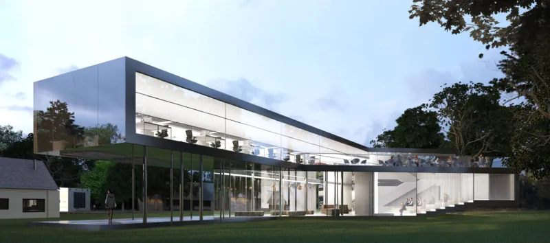 Contemporary glass office building on a grassy lawn with trees; two-story curved facade, people visible inside through large windows.
