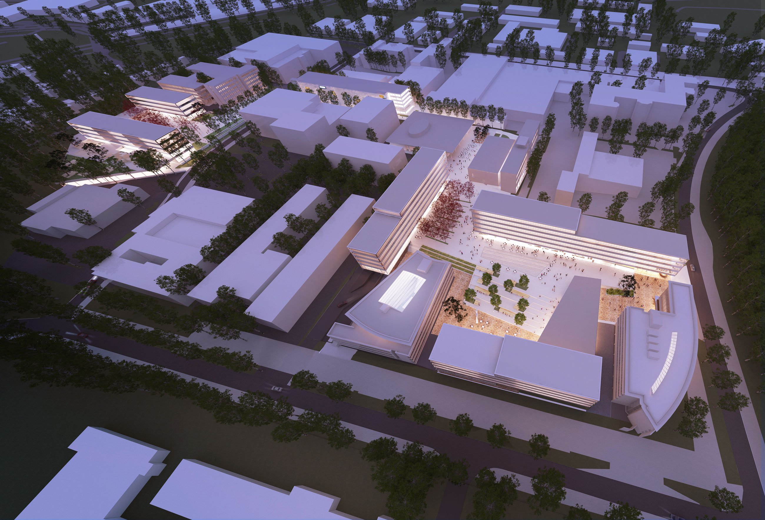 Aerial view of a modern university campus with rectangular buildings around a central plaza; dusk lighting and people in the plaza.