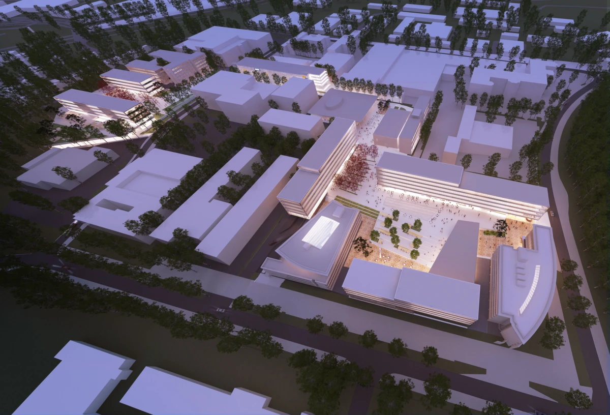 Aerial view of a modern university campus with rectangular buildings around a central plaza; dusk lighting and people in the plaza.