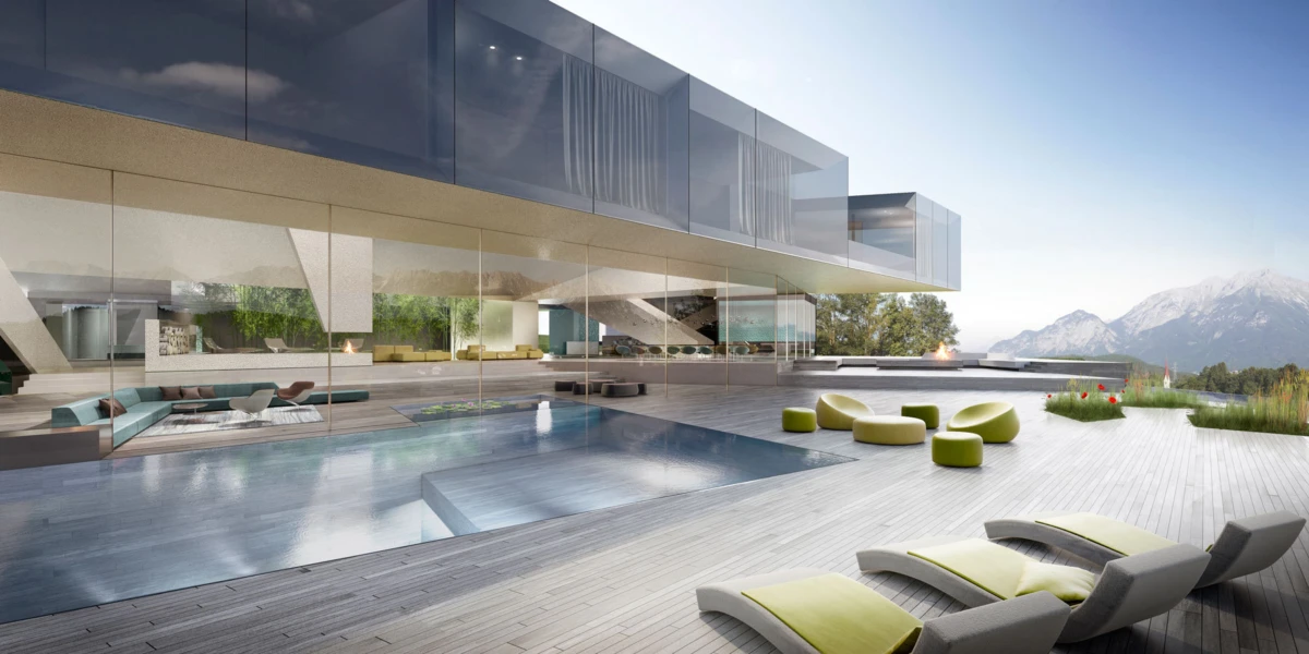 Modern glass-walled villa with an outdoor pool and lounge seating on a wooden deck, with mountains in the background.