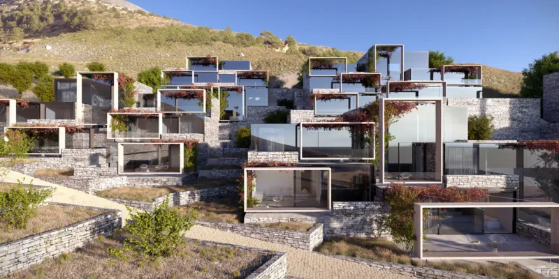 Terraced hillside housing complex of glass-fronted cubic homes with stone retaining walls and greenery.
