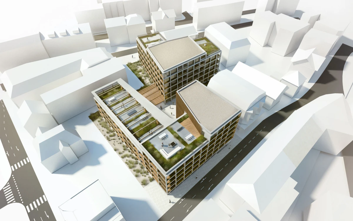 Aerial view of a modern brick office complex with green roofs and a wooden deck, surrounded by white city buildings.