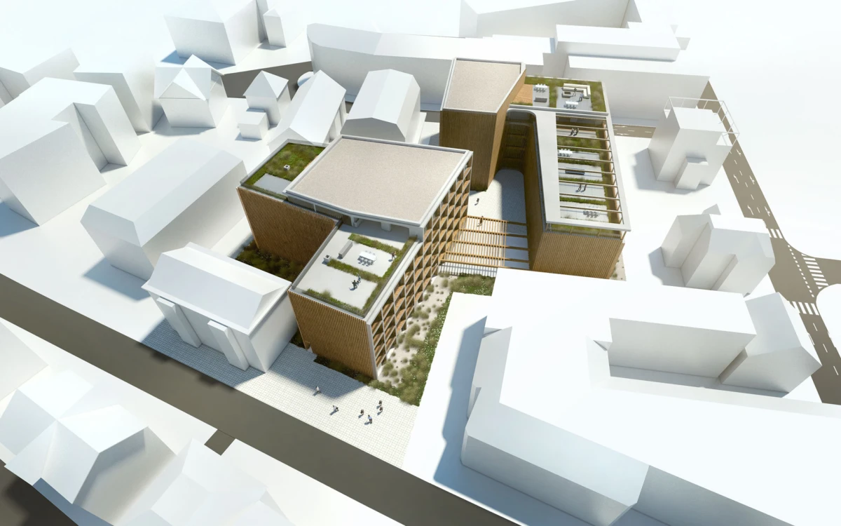 Aerial view of a modern brick office complex with green rooftop gardens and internal courtyards, connected by walkways, in a white urban block.